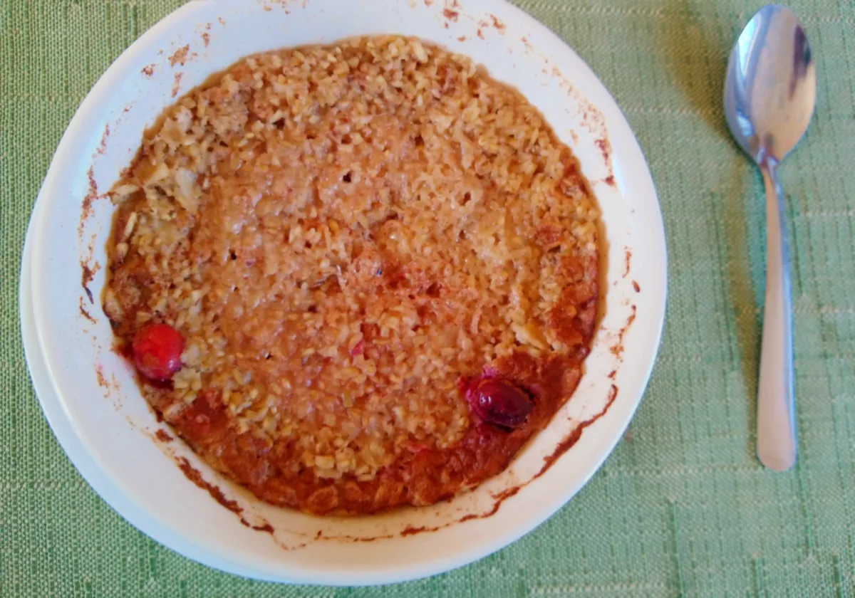 A bowl of porridge with cranberries after cooking.